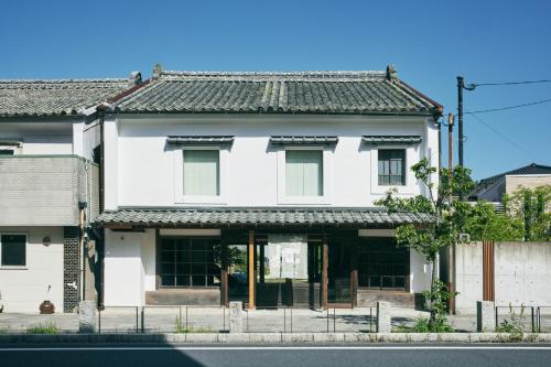 a white house on a street at hotel jin #JIN in Tsushima