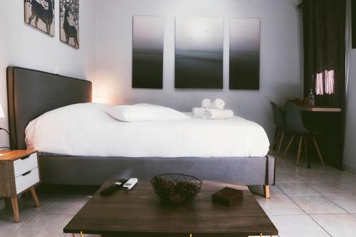 een slaapkamer met een wit bed en een tafel bij Gk Suites-Constantin view , auto check-in 24h in Larisa