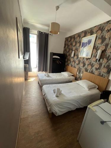 una habitación de hotel con 2 camas en una habitación en Hôtel Trianon, en Juan-les-Pins
