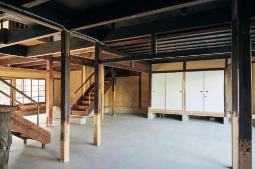 a large room with wooden beams and a staircase at hotel jin #JIN in Tsushima