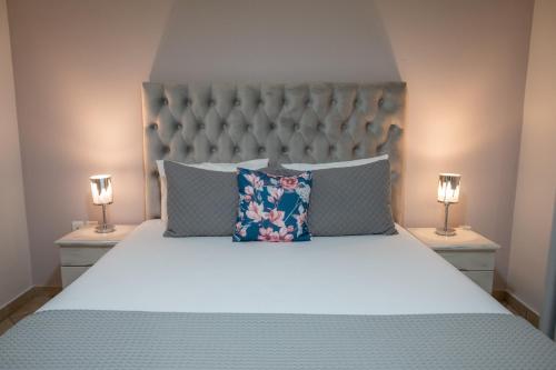 a bedroom with a large bed with two lamps at Katerina Roza Studios - Heartfelt Hospitality in the City in Naxos Chora