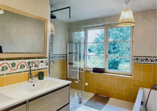 une salle de bain avec un lavabo et une fenêtre dans l'établissement Chambre rose entre Lyon et Beaujolais - piscine, à Lentilly