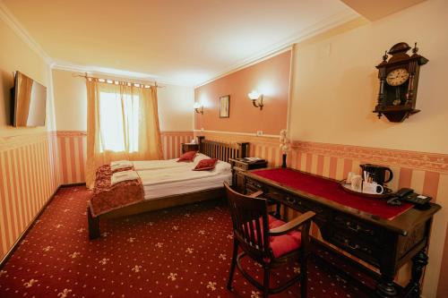 a bedroom with a bed and a desk and a clock at Casa del Sole Boutique Hotel Timisoara in Timişoara