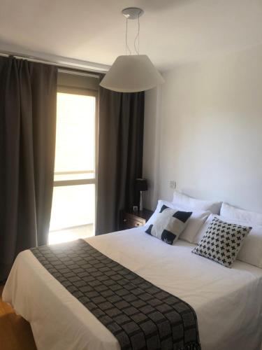 a bedroom with a large white bed with a window at Habitacion con baño privado in Madrid