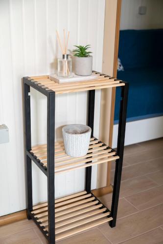a black and wooden shelf with a plant on it at Dimitra's Apartment in Makri