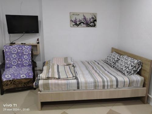 a small bedroom with a bed and a tv at Квартира-студия с видом на море in Ureki