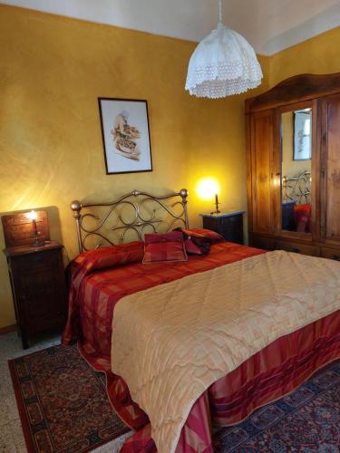1 dormitorio con 1 cama grande con manta roja en La Corte del Barbio, en Aramengo