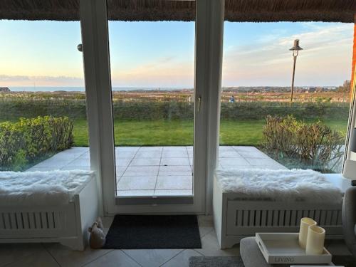 a room with a large glass door to a patio at Haus Kampbarg Suite 2-Meer-Blick in Kampen