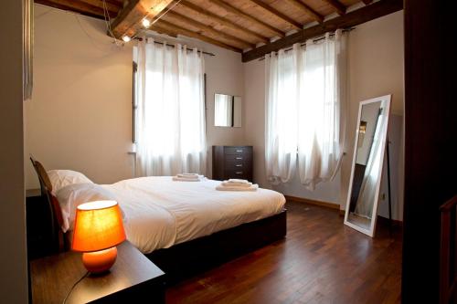 a bedroom with a bed and a table with a lamp at Casa del Sensale in Lucca