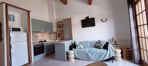 - une cuisine avec un canapé bleu dans une chambre dans l'établissement Appartement Papillon avec Piscine et Vue Mer, à Propriano