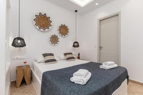 Un dormitorio blanco con una cama con toallas. en Mare Monte Studios Naxos, en Plaka