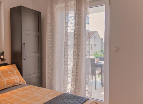 Un dormitorio con una cama y una puerta corrediza de vidrio. en ULA LA apartment, en Umag