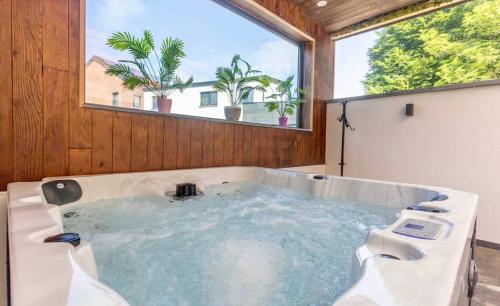 una grande vasca da bagno in una stanza con finestra di Maison de vacances a Dalhem