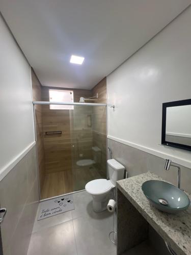ein Bad mit einem WC, einem Waschbecken und einer Dusche in der Unterkunft Executivo Veneza in Ipatinga