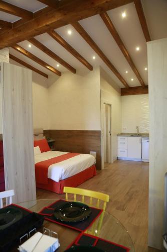 a bedroom with a bed and a table and a kitchen at Apartamentos La Arena in Miengo