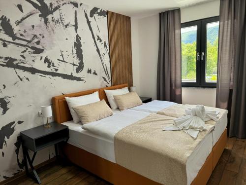 um quarto com uma cama grande e uma pintura grande na parede em Hotel Turist 98 em Jajce