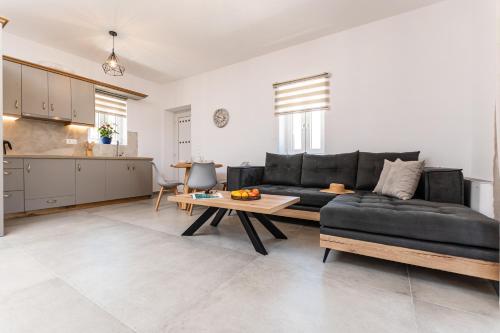 uma sala de estar com um sofá preto e uma mesa em Marble Arch Apartments em Naxos Chora