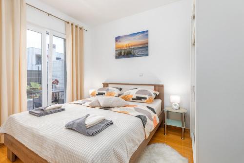 プーラにあるApartman Sunny Lenaのベッドが2つと大きな窓がある寝室