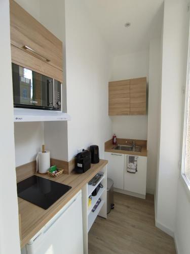 une petite cuisine avec des armoires blanches et un évier dans l'établissement Studio mezzanine, à Cannes