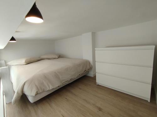 une chambre blanche avec un lit et une commode dans l'établissement Studio mezzanine, à Cannes