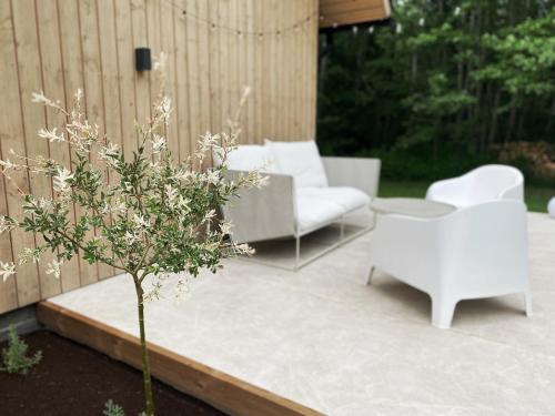 a patio with a couch and chairs and a tree at Heinaläku puhkemaja loft in Paope