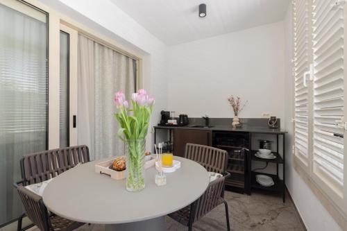 a dining room with a white table with flowers on it at Makarska City Bay Studios in Makarska