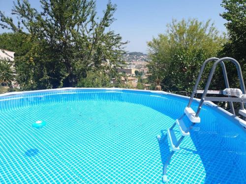 - une piscine bleue avec une balançoire dans la cour dans l'établissement F3 dans une villa SuperCannes, à Vallauris