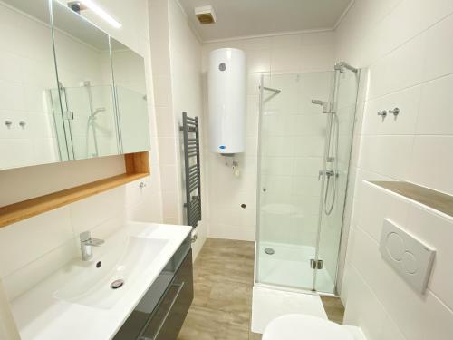 a white bathroom with a sink and a shower at Landgasthof Schmid - Unterkunft & Restaurant in Sitzenberg