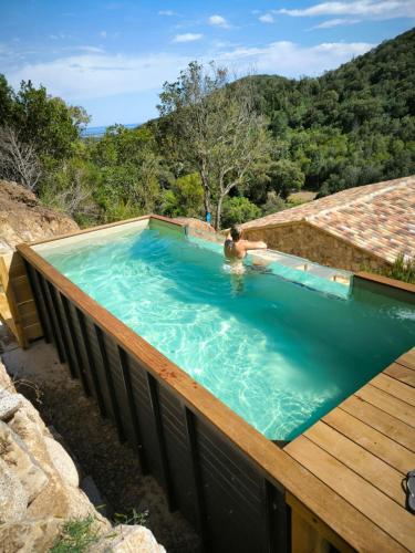 une piscine avec une terrasse en bois et une personne dans l'eau dans l'établissement 