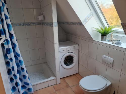 ein Bad mit einer Waschmaschine und einem Fenster in der Unterkunft Treeneperle in Schwabstedt