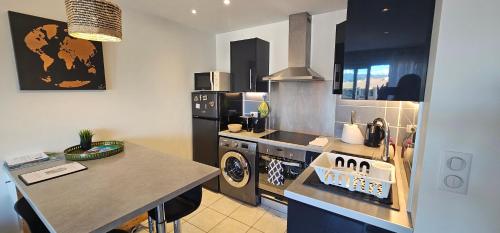 a kitchen with a stove and a sink and a counter at Appartement 2 pièces Cosy au calme climatisé 3 étoiles in Fréjus