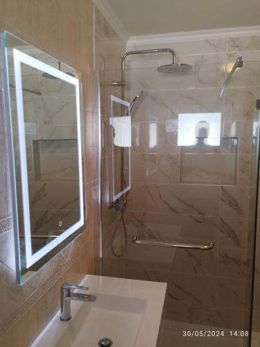 a bathroom with a sink and a shower with a mirror at Condo do Mar Lovely first floor apartment with pool in Lagos