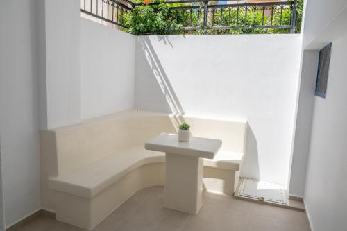 a white room with a bench and a window at Katerina Roza Studios - Heartfelt Hospitality in the City in Naxos Chora