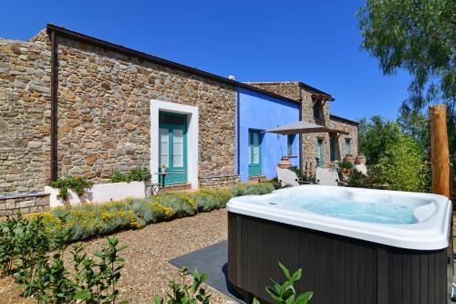 un bain à remous en face d'une maison en pierre dans l'établissement Terre Di Himera, à Buonfornello