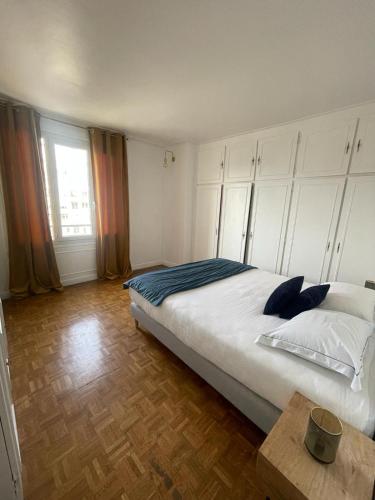 Un dormitorio con una cama grande y una ventana en magnifique appartement, en París