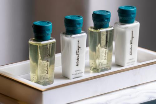 cuatro botellas de perfume sentadas en un estante en Golden Sands Boutique Hotel-Dubai Creek en Dubái