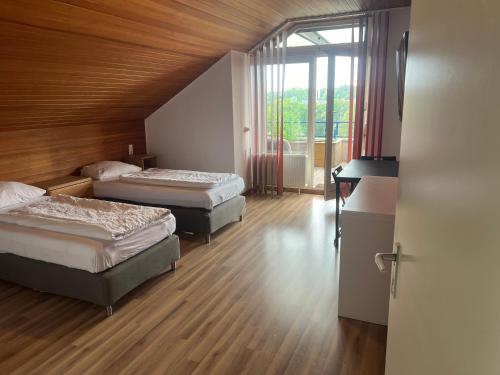 a bedroom with two beds and a large window at Hotel Hages in Bad Salzuflen