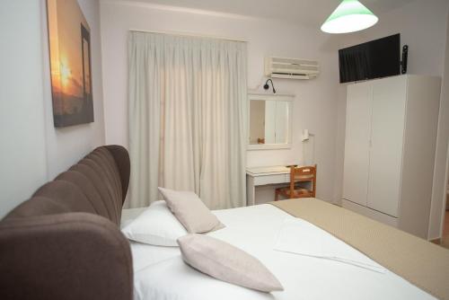 a bedroom with a large white bed with two pillows at Katerina Roza Studios - Heartfelt Hospitality in the City in Naxos Chora