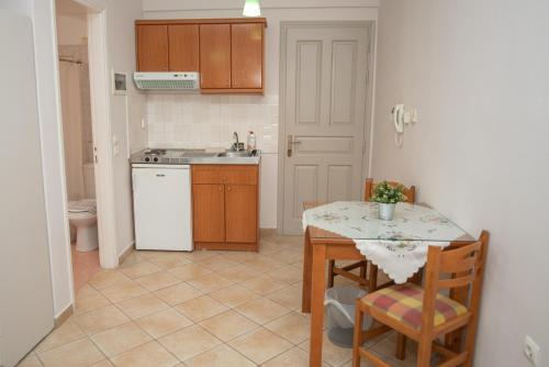 a kitchen with a table and a kitchen with a sink at Katerina Roza Studios - Heartfelt Hospitality in the City in Naxos Chora