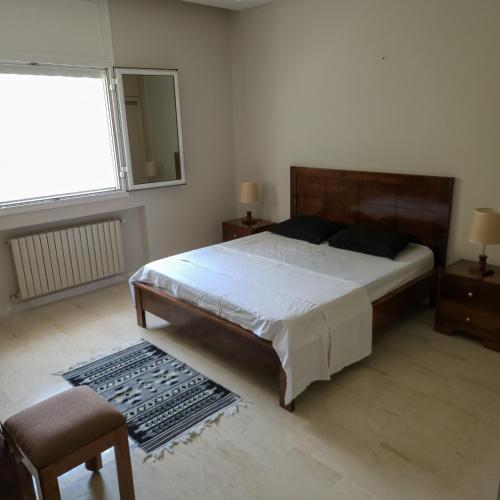 Un dormitorio con una cama grande y una ventana en Villa Sérénité, Yasmine Hammamet, en Hammamet