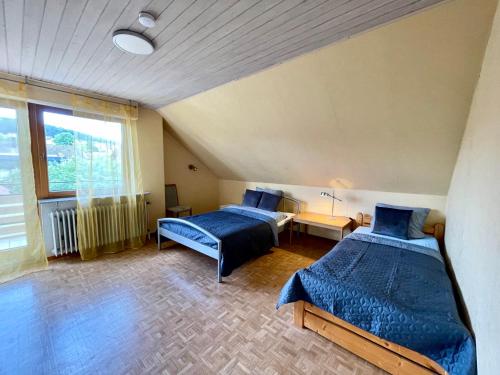 a bedroom with two beds and a window at Ferienwohnung am Schwarzwald in Althengstett