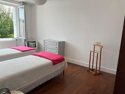 une chambre avec deux lits et une commode et une fenêtre dans l'établissement Ty Mimi, à Plougastel-Daoulas