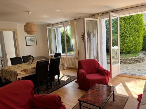 un salon avec une table et des chaises rouges dans l'établissement Ty Mimi, à Plougastel-Daoulas
