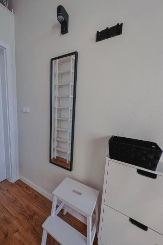 a white room with a mirror and a table and stool at Chce się być in Ślesin