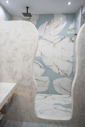 a bathroom with a white marble wall at Katerina Roza Studios - Heartfelt Hospitality in the City in Naxos Chora