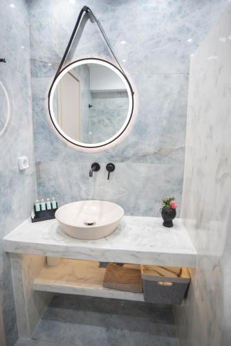 a bathroom with a sink and a mirror at Katerina Roza Studios - Heartfelt Hospitality in the City in Naxos Chora