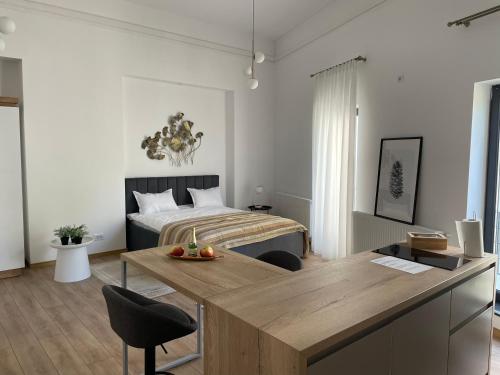 a bedroom with a bed and a table in front of it at Aris Ultracentral&Cozy Studios PIATA UNIRII in Iaşi