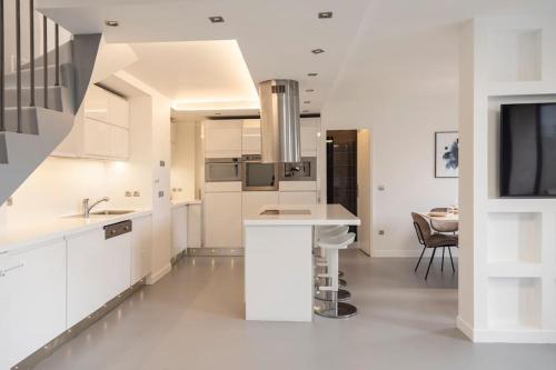 une cuisine blanche avec un évier et un comptoir dans l'établissement Loft de luxe aux portes de Paris, à Montreuil