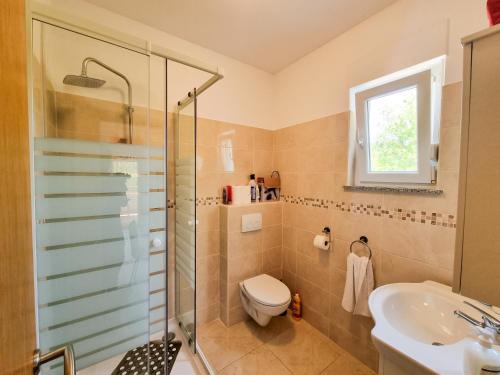 y baño con ducha, aseo y lavamanos. en Apartments & Room Danijel en Pinezici