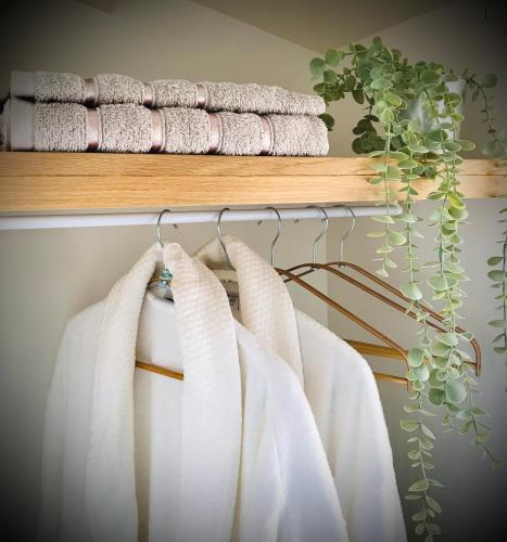 a group of white towels hanging on a rack at Suite Spa et Sauna de Cogny in Cogny